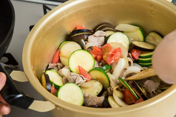 鍋にカレーの野菜の具材をいれて混ぜている料理途中
