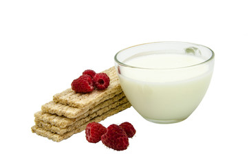 Crispbread from wheat on an isolated background. Mature raspberry berries and a mug of milk. Wheat...