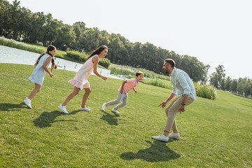 Playing with family. Active and happy young family playing and smiling while spending free time...