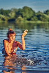 girl in the water in the lake at sunset
