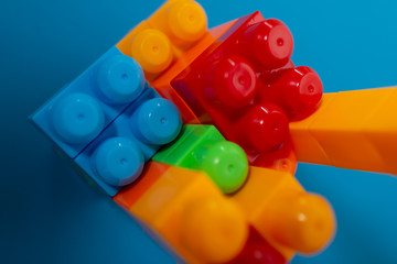 Business concept of success, teamwork and building a business. Color toy blocks on blue background