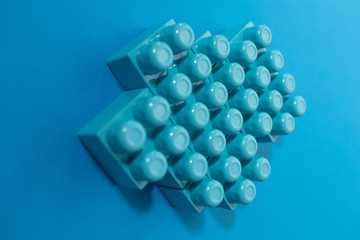 Business concept of success, teamwork and building a business. Color toy blocks on blue background