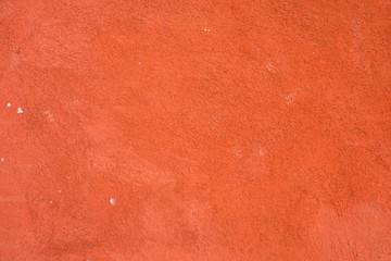 Brick wall, plastered wall, rough surface, painted red..The walls decorate the exterior buildings that are painted red.