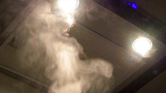 Close up shot of steam rising into a rangehood extractor fan in a kitchen