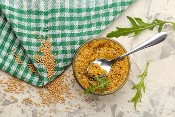 Mustard sauce, French Mustard in a bowl and dry grains on a light concrete table. close-up. top view
