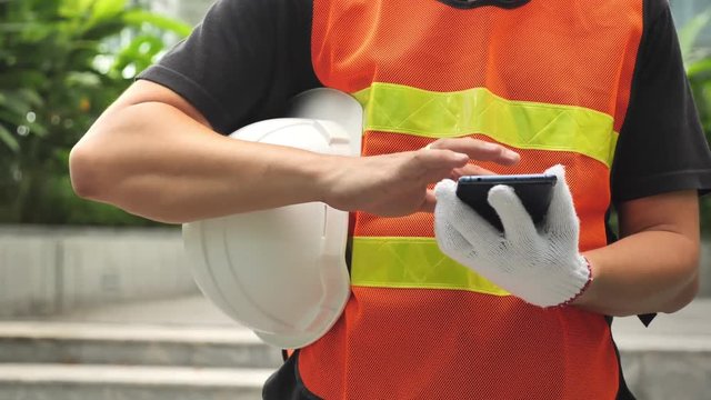 Quality engineers or construction teamwork. Safety concern for engineering or building work site or plant. Wearing helmet and Check through the application on the smartphone via the 5G system.