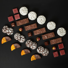 A set of home-made sweets: brownies, marshmallows, cookies, marmalade, delicious slices of orange in chocolate and candies.