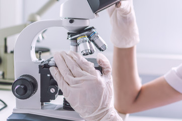 Hands with microscope in the laboratory