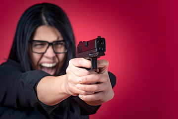 Angry business woman shooting her gun
