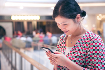 Woman using smartphone inside shopping mall