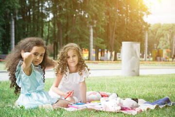 Naklejka premium two little girls lying down in the grass and having fun