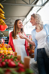 Young women shopping on the market healthy vegetables and fruits