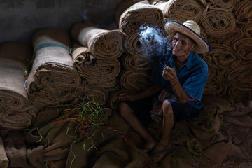 Old man smoking cigarette and the smoke released from the mouth, Bad habits concept..