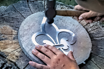 Working with hammer during hand stamping or engraving decoration pattern on metal ornamen