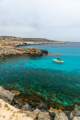 CYPRUS, CAPE CAVO GRECO - MAY 11/2018: Tourists sailed on a motor boat into the blue lagoon for swimming.