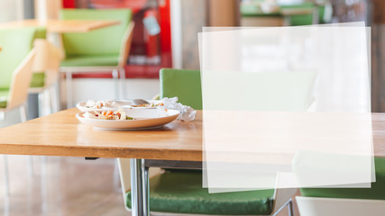 White plates with food leftover and some garbages on wooden table. Food waste and environmental saving concept with white text box.