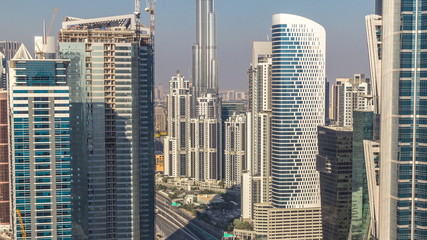 Naklejka premium Aerial view of towers in Business Bay with traffic on the road timelapse.