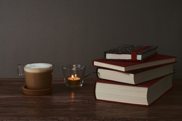  Coffee and books on a brown wooden table.