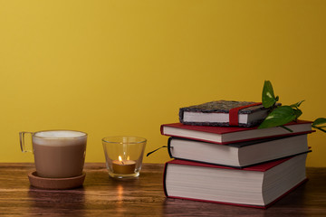  Coffee and books on a brown wooden table.