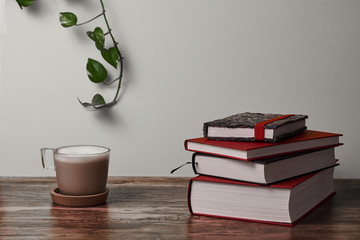  Coffee and books on a brown wooden table.