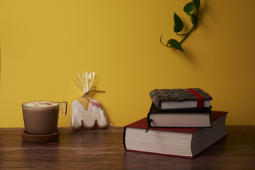  Coffee and books on a brown wooden table.