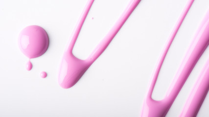 Pink nail polish drips on a white background.