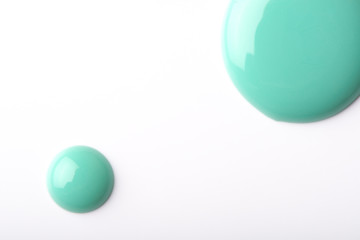 Green nail polish on a white background.