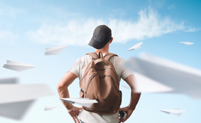 Several origami paper planes fly around a man.