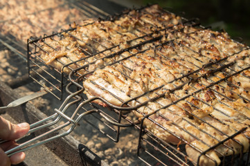 Shish kebab grilled in nature. Grilled meat on the grill. Picnic. Cook the meat on the grill.