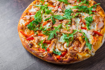 Pizza with Mozzarella cheese, salmon fish, tomato sauce, pepper. Italian pizza on wooden table background