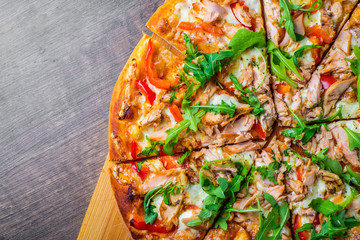 Pizza with Mozzarella cheese, salmon fish, tomato sauce, pepper. Italian pizza on wooden table background