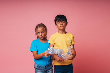 Two little boys holding a plastic bottles for recycling