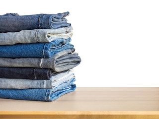 denim blue jeans stack on wood table isolated on white background