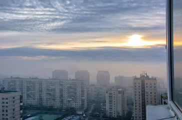 Fototapeta na wymiar Fog like a cloud covering part of the houses in the city.