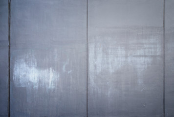 High resolution full frame background of a concrete wall painted in gray with lighter marks as a result of graffiti removal. Copy space and vignetting.