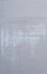 High resolution full frame background of a concrete wall painted in gray with lighter marks as a result of graffiti removal. Copy space.