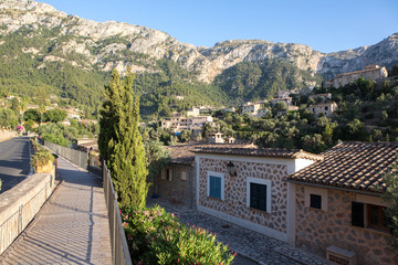 Obraz premium Beautiful view of old mountain village Deia in Mallorca on a sunny day. Deia traditional stone village in Majorca Tramuntana mountain