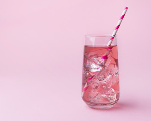 Pink rose cocktail on a pink background with striped pink straw.