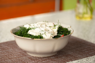 Green vegetables salad. Tomatoes, cucumbers, onions, parsley, fennel, sour cream. A table in summer cafe.