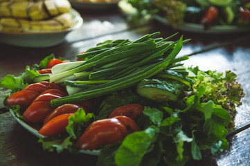 Vegetables and fruits are sliced on a wooden table. Picnic in the summer. Fresh vegetables. Party in nature.