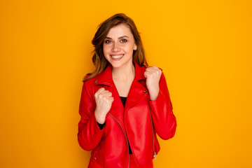 Happy attractive woman celebrating success isolated in a yellow sstudio