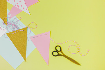 Bunting paper and scissor on green background