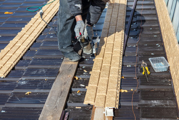 Worker installs plastic panels with bricks