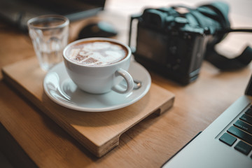 Latte coffee and camera in the coffee shop is time relaxation of freelance photographer.