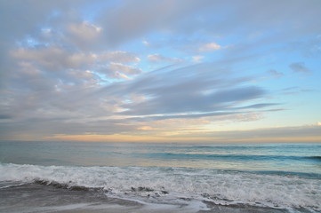 Obraz premium cirrus clouds over the sea at sunset. romantic seascape sunset in pastel colors. pastel sunset sky with cloudscape over the Black sea