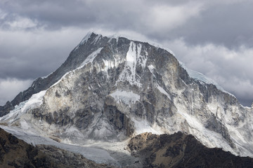 beautiful snow and ice mountain peak in evening light under an expressive sky