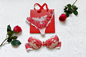 Red women's lingerie and accessories on white surface. Flat lay.