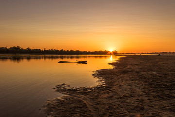 Fototapeta premium Peaceful lanscape with the beach and river during the sunset. 