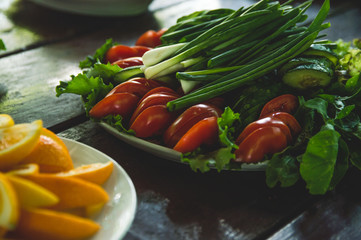 Vegetables and fruits are sliced on a wooden table. Picnic in the summer. Fresh vegetables. Party in nature.