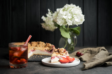 Fototapeta na wymiar Summer dessert. Rustic berry cake with a delicate souffle and strawberry homemade lemonade on a dark background.